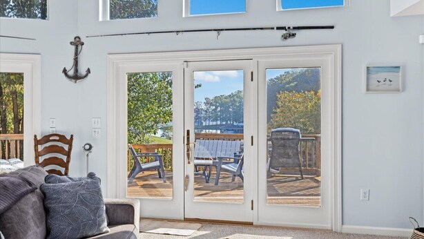 A room with a large sliding glass door leading to an outdoor deck with outdoor furniture.