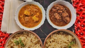 Une table avec trois bols de curry et deux bols de riz.