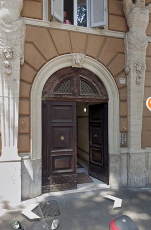 An arched entrance with a dark wooden door and a window above. - Giulio Cesare Flat - Prati  (Roma)