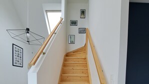 A wooden staircase with white walls and a dark blue door at the top. - Cosy, bright house close to amenities in Mordelles (Mordelles)