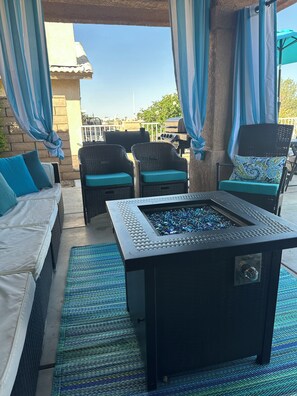 An outdoor seating area with wicker furniture, a fire feature, and a view of the surrounding area. - Driftwood Cove Lake House – Waterfront, Pet-Friendly, Private Dock in Helendale (Helendale CA)