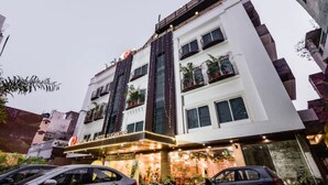 A multi-story hotel with balconies, a sign reading "Capital Hotel Yugantar," and a well-lit entrance.