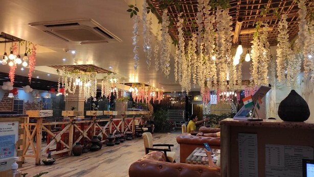 An interior with hanging floral decorations, wooden furniture, and a seating area.