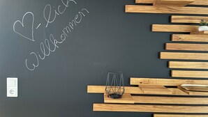 A wall with a blackboard displaying the text "Willkommen" and a welcome sign.