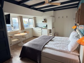 Een slaapkamer met een bed, een bureau en een raam.