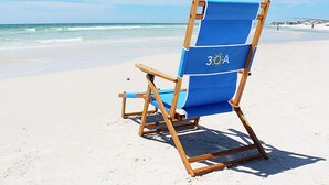 A blue beach chair with a sun symbol and the number 30A on it, placed on a sandy beach with the ocean in the background. - ☀️Beach Access-3 Pools-Gulf View-Gulf Place Cabanas 210 (Santa Rosa Beach)
