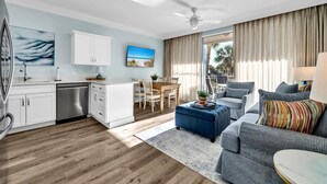 A modern living room with a sofa, a dining table, and a kitchen area. - ☀️Beach Access-3 Pools-Gulf View-Gulf Place Cabanas 210 (Santa Rosa Beach)