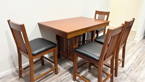 A dining table with four wooden chairs, each with a black seat cushion. - Stylish Historic Loft in Downtown Dubuque. Walk to Dining & Riverwalk (Dubuque)