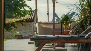 Un espace patio avec un banc en bois et un grand parasol.