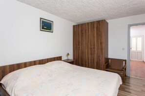 Relax in this cozy retreat with a large bed, a wardrobe, and a comfortable chair.