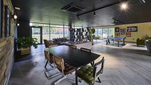 A modern meeting room with a large table, comfortable chairs, a bookshelf, and a ping pong table. - For Students Only Nottingham Two (Nottingham)