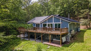 A house with a deck, large windows, and a stone foundation. - Deep Creek Escape: w/ Theater, Fire Pit & Dock (Swanton)