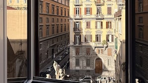 A view from a window of a building with multiple floors, featuring classic architecture with balconies and a red roof. - Unicum Suite Grande Archivio Napoli  (Naples)