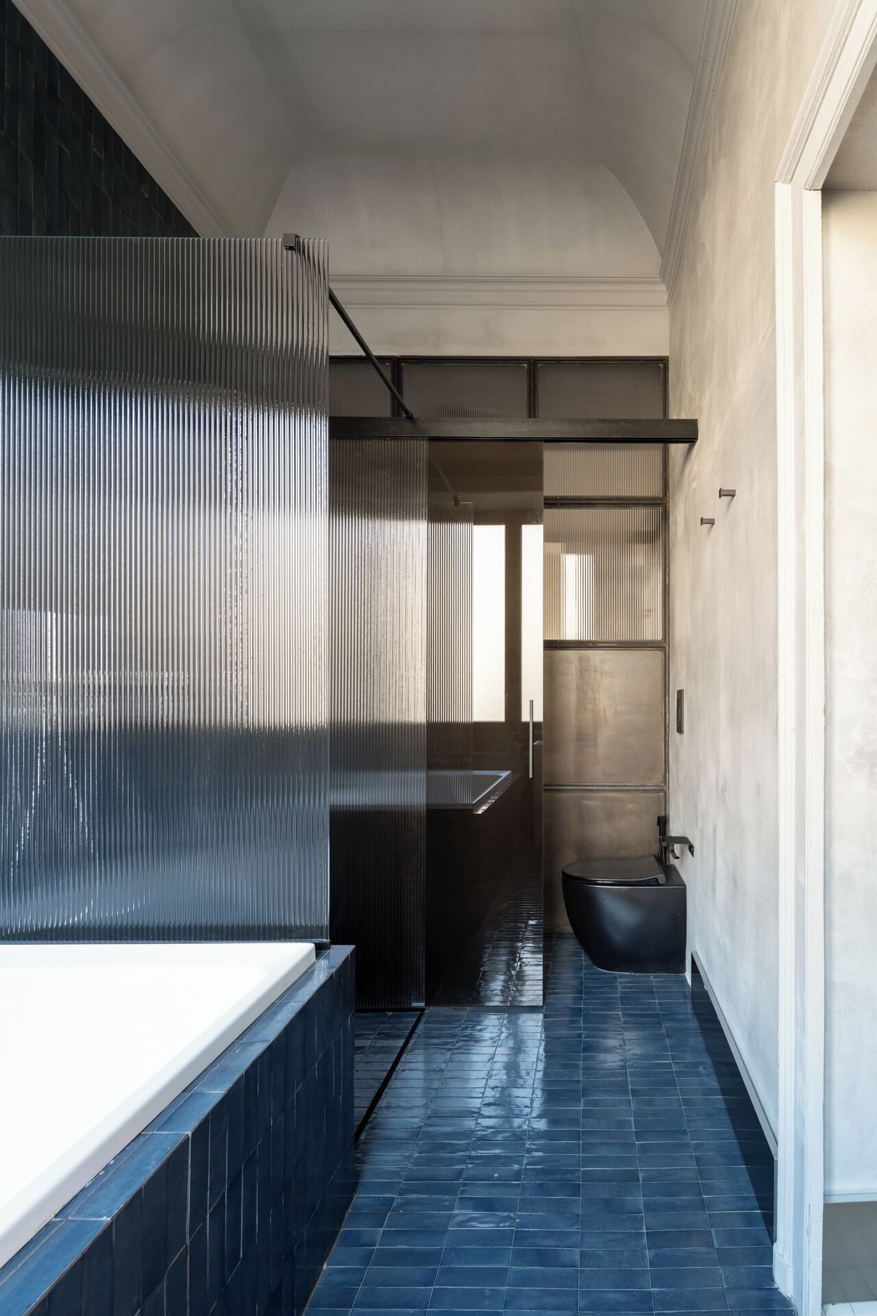 A modern bathroom with a large bathtub, a toilet, and a sink.