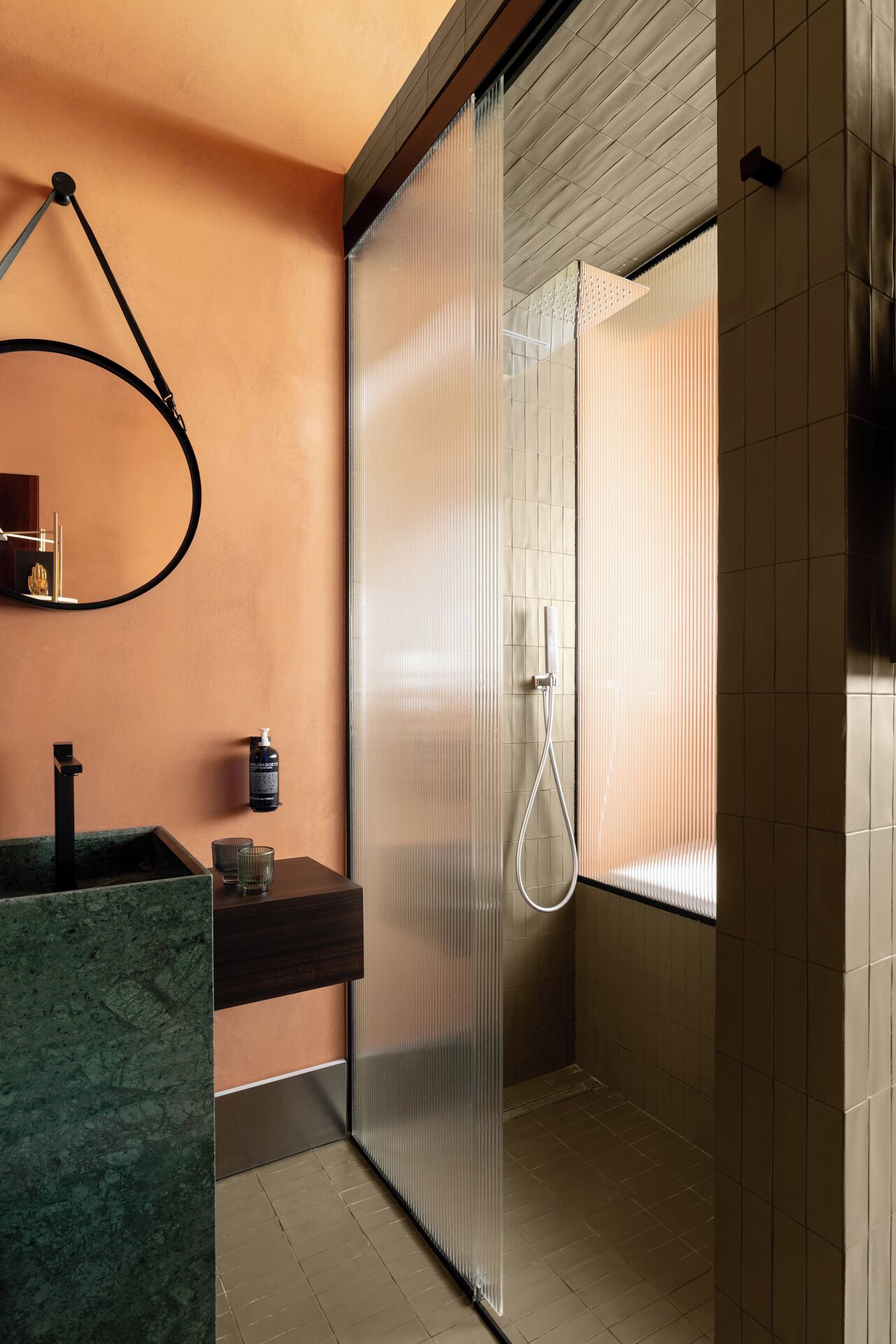Ein modernes Badezimmer mit Dusche, Waschbecken und Marmorplatte sowie einem Handtuchhalter.