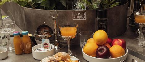 Una mesa con diferentes alimentos, bebidas y una máquina de café.