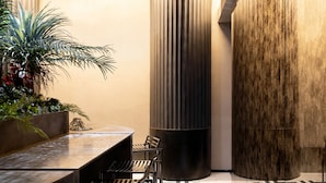 A modern interior with a bar area, seating, and a decorative wall. - Unicum Suite Grande Archivio Napoli  (Naples)