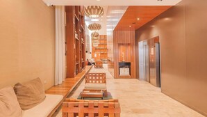 A modern hotel lobby with a wooden bench, a sofa, and a reception desk. - Disfruta este Genial Dep en PalermoT707 (Buenos Aires)