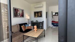 Ein modernes Wohnzimmer mit einer Couch, einem Couchtisch und einem Essbereich.