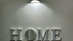 A wall with the word "HOME" in large, metallic letters. - R home double room with private bathroom (Ischia)