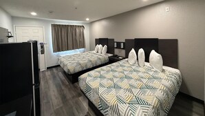 Une chambre d’hôtel avec deux lits, un réfrigérateur, une fenêtre avec des rideaux et une porte.
