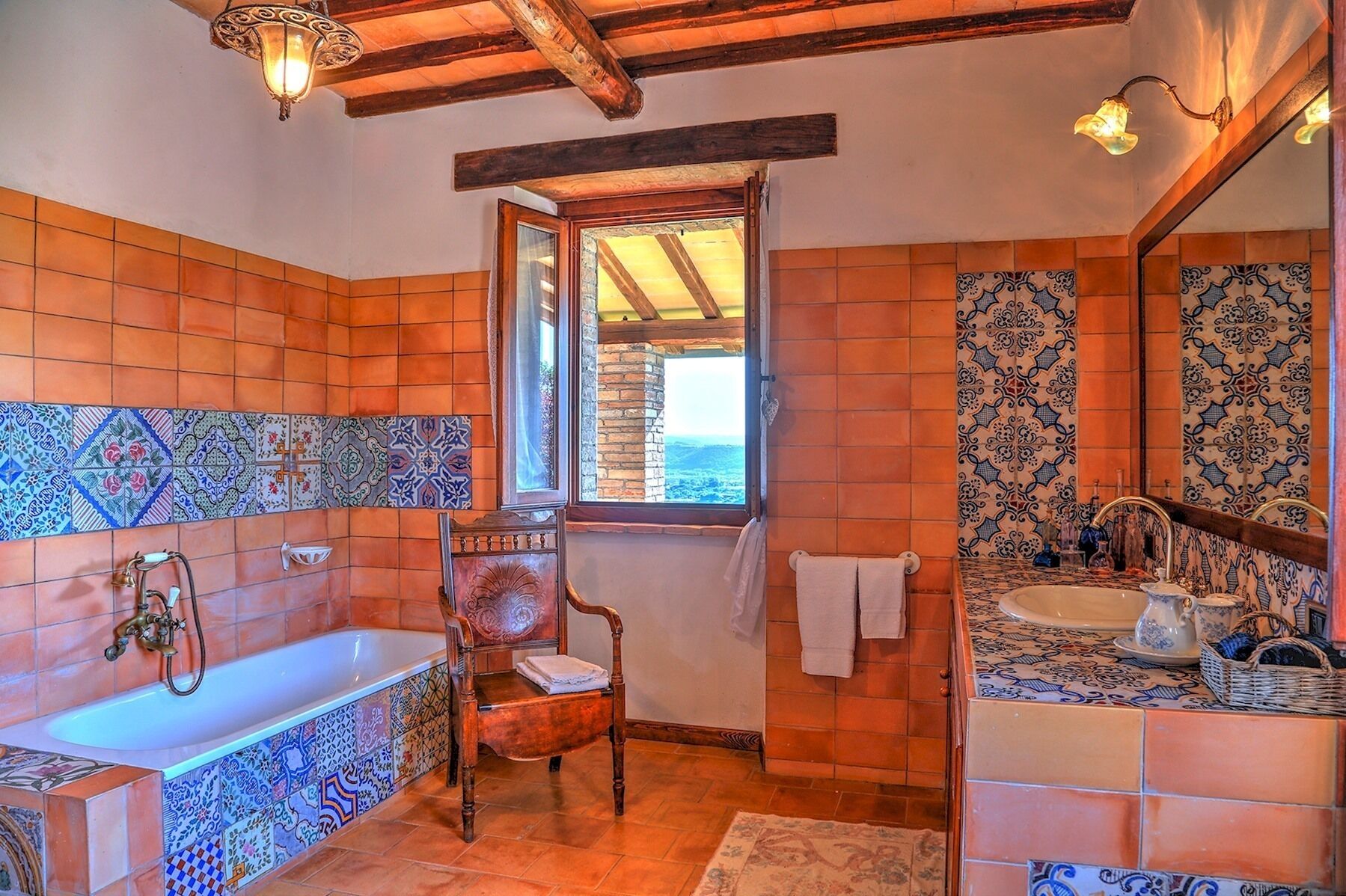Ein Badezimmer mit einer Badewanne, einem Holzstuhl, einem Fenster und einer Fliesenarbeitsplatte.