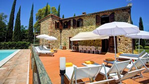 A stone building with a pool, outdoor seating, and umbrellas. - La Magia 8+2, Emma Villas (Gavorrano)