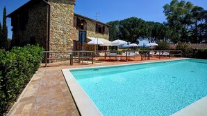 A stone building with a pool, outdoor seating, and umbrellas. - La Magia 8+2, Emma Villas (Gavorrano)