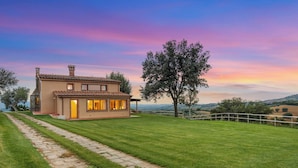 A two-story house with a paved driveway and a well-maintained lawn. - Casale Ombrone 11, Emma Villas (Campagnatico)