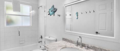 A bathroom with a bathtub, toilet, and sink.