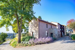 A two-story building with a stone facade and a gravel driveway.