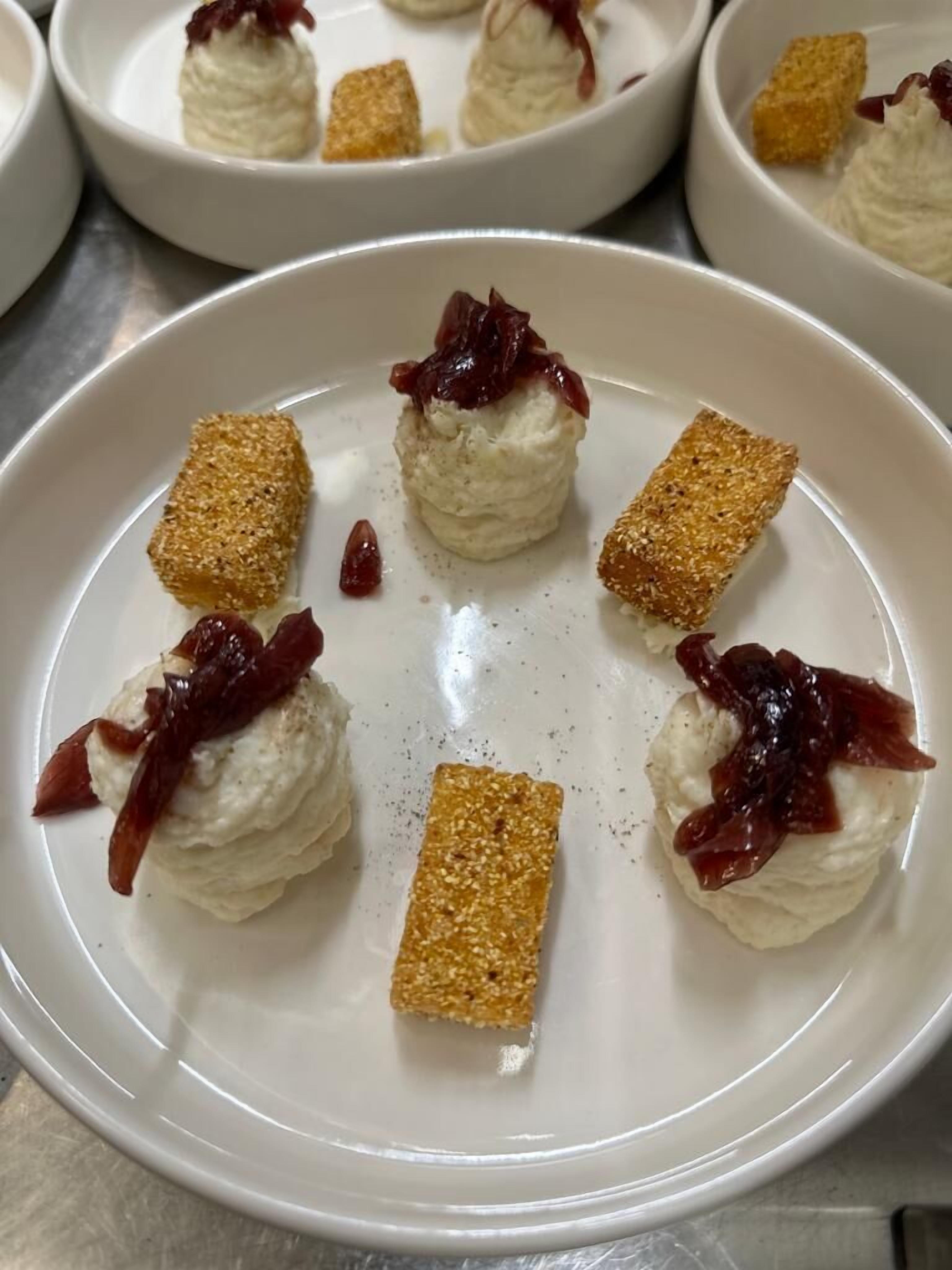Une assiette à dessert garnie de crème fouettée et de fruits, entourée d’assiettes similaires.
