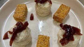 Une assiette à dessert garnie de crème fouettée et de fruits, entourée d’assiettes similaires.