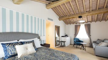 Une chambre avec un grand lit, un bureau, une chaise et un canapé.