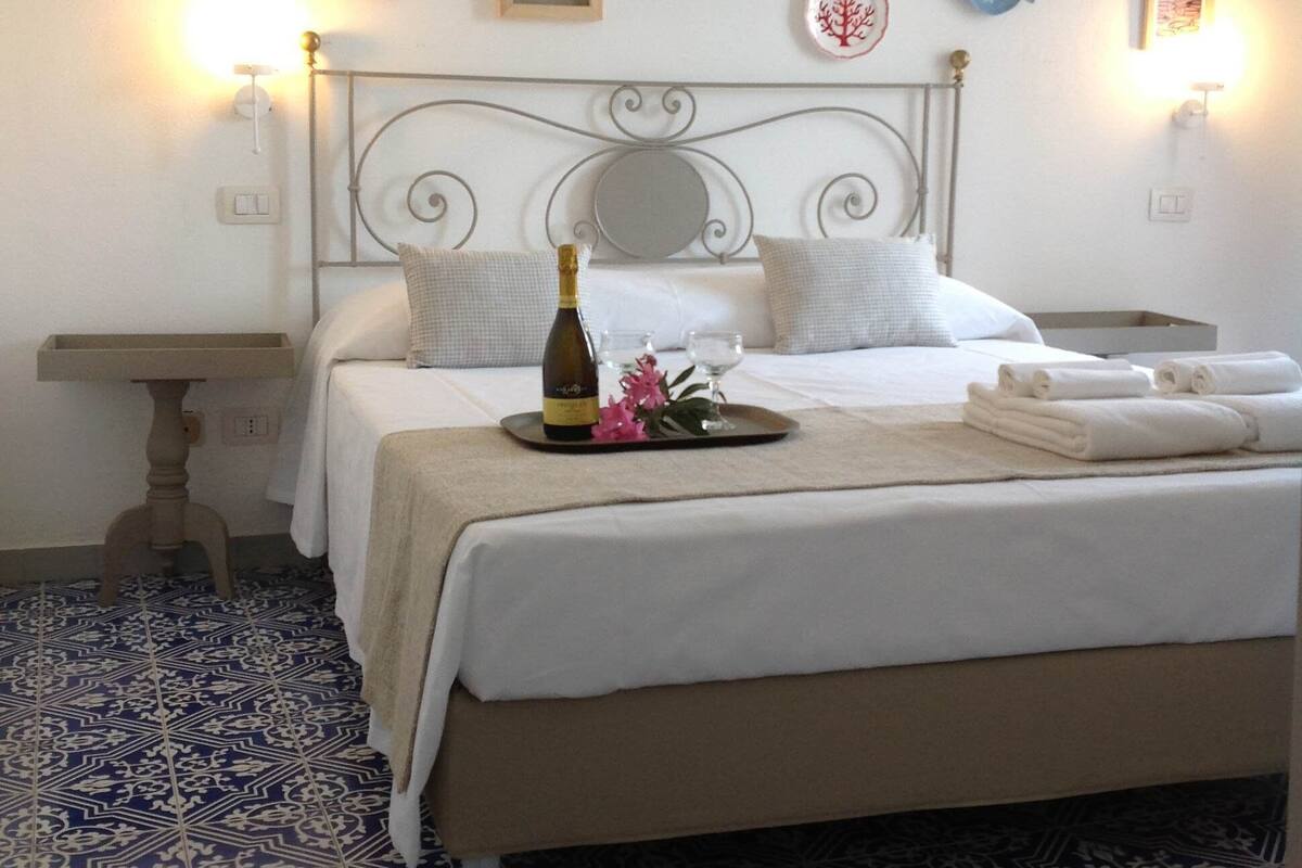 A neatly arranged bedroom with a bed, bedside tables, and wall decorations.