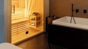 Ein modernes Badezimmer mit einer Holzausstattung, einer großen Badewanne und Holzboden.