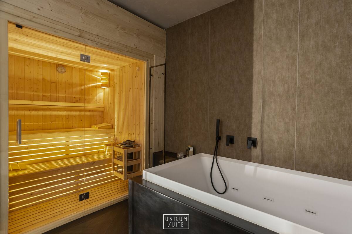 A modern bathroom with a wooden sauna, a large white bathtub, and a minimalist design.