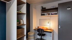 A compact office space with a desk, chair, shelves, and a door. - For Students Only Regents Court in Leicester (Leicester)