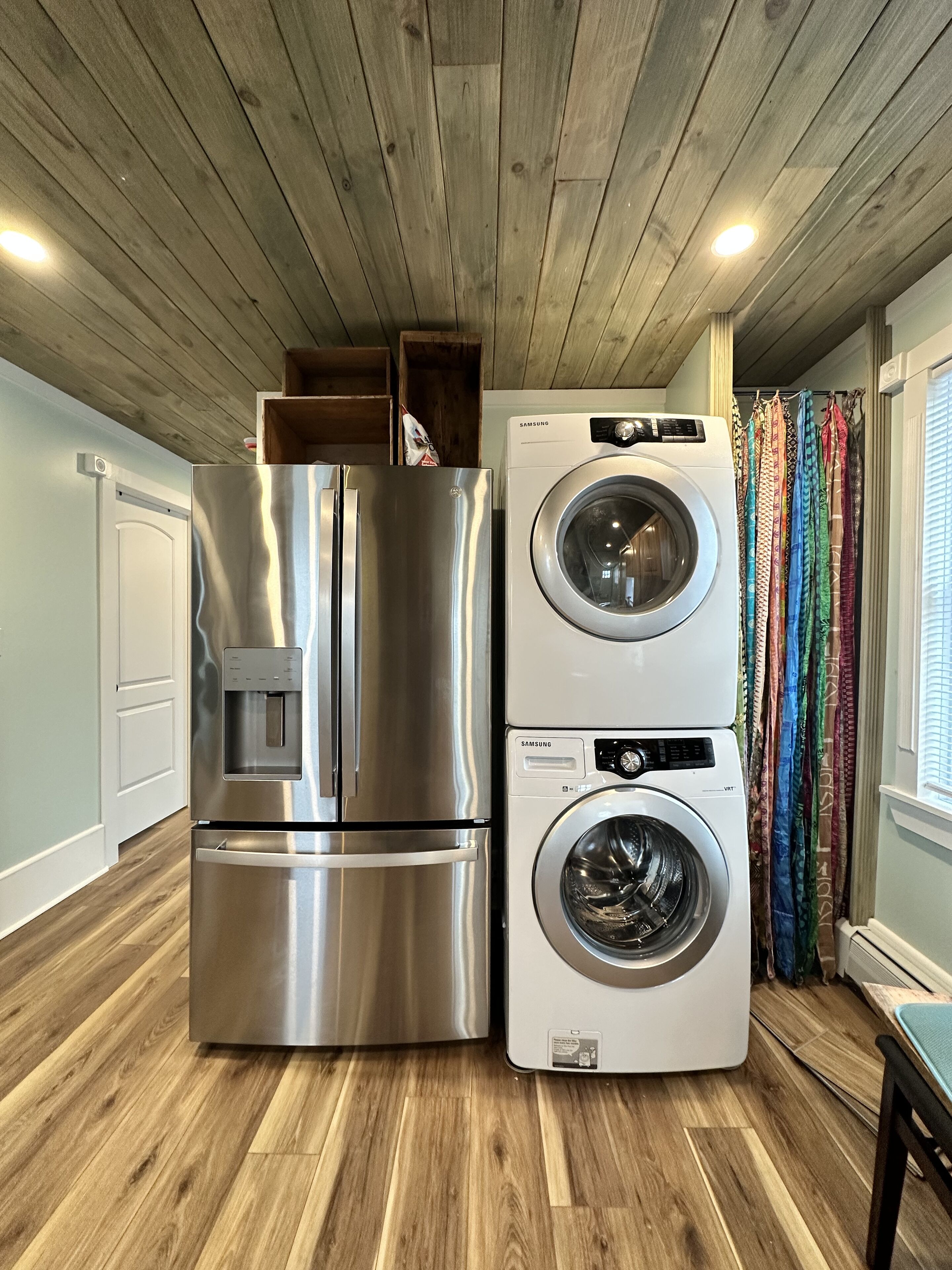 Una cocina compacta con un refrigerador de acero inoxidable y lavadora y secadora integradas.