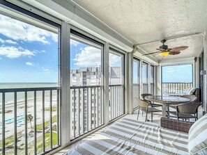 A balcony with a view of the beach, a ceiling fan, and outdoor furniture. - Beachfront Getaway at Caper Beach Club #PH12 | Private Chiller/Heated Pool (Fort Myers Beach)