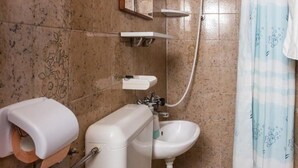 Ein Badezimmer mit Toilette, Waschbecken und Dusche.