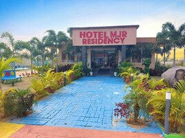 A hotel entrance with a sign reading "HOTEL MJR RESIDENCY".