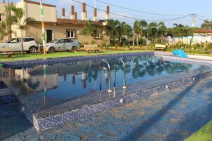 A swimming pool with a tiled edge and a blue mosaic pattern.