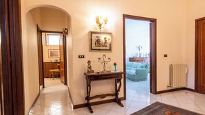 A hallway with a wooden console table, a framed picture, and a radiator.