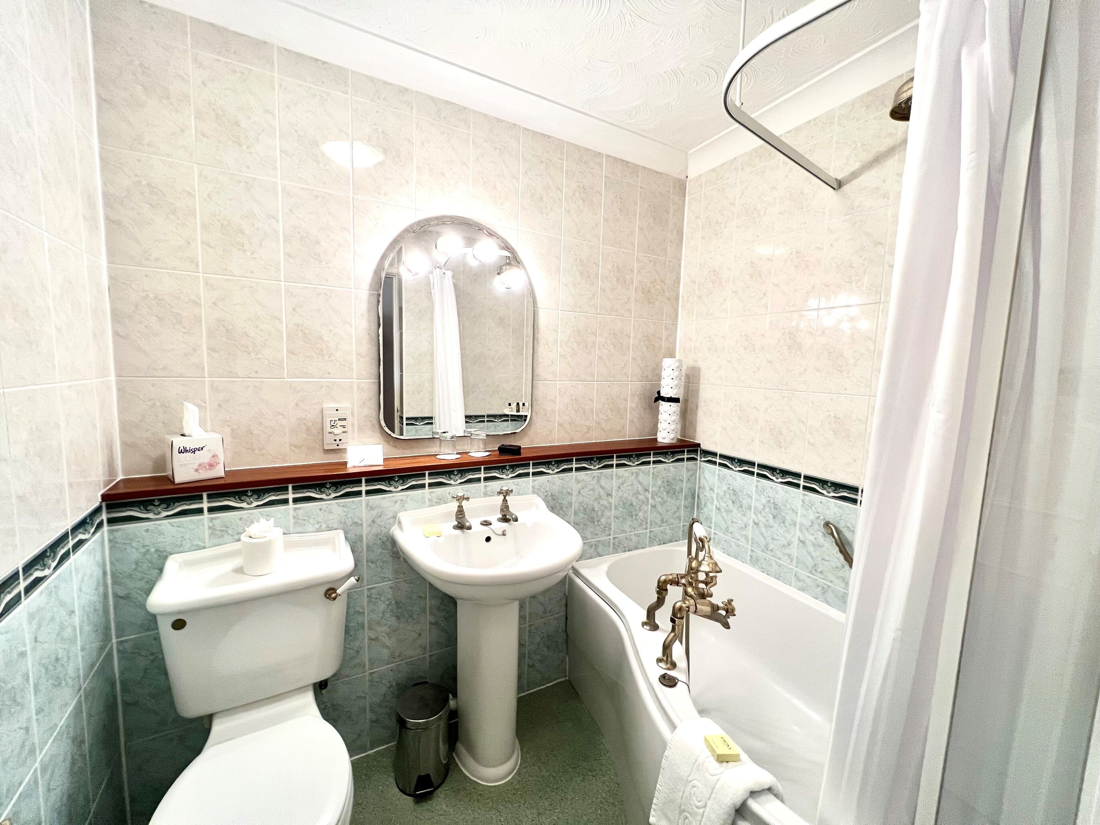 Un baño con inodoro, lavamanos y bañera.