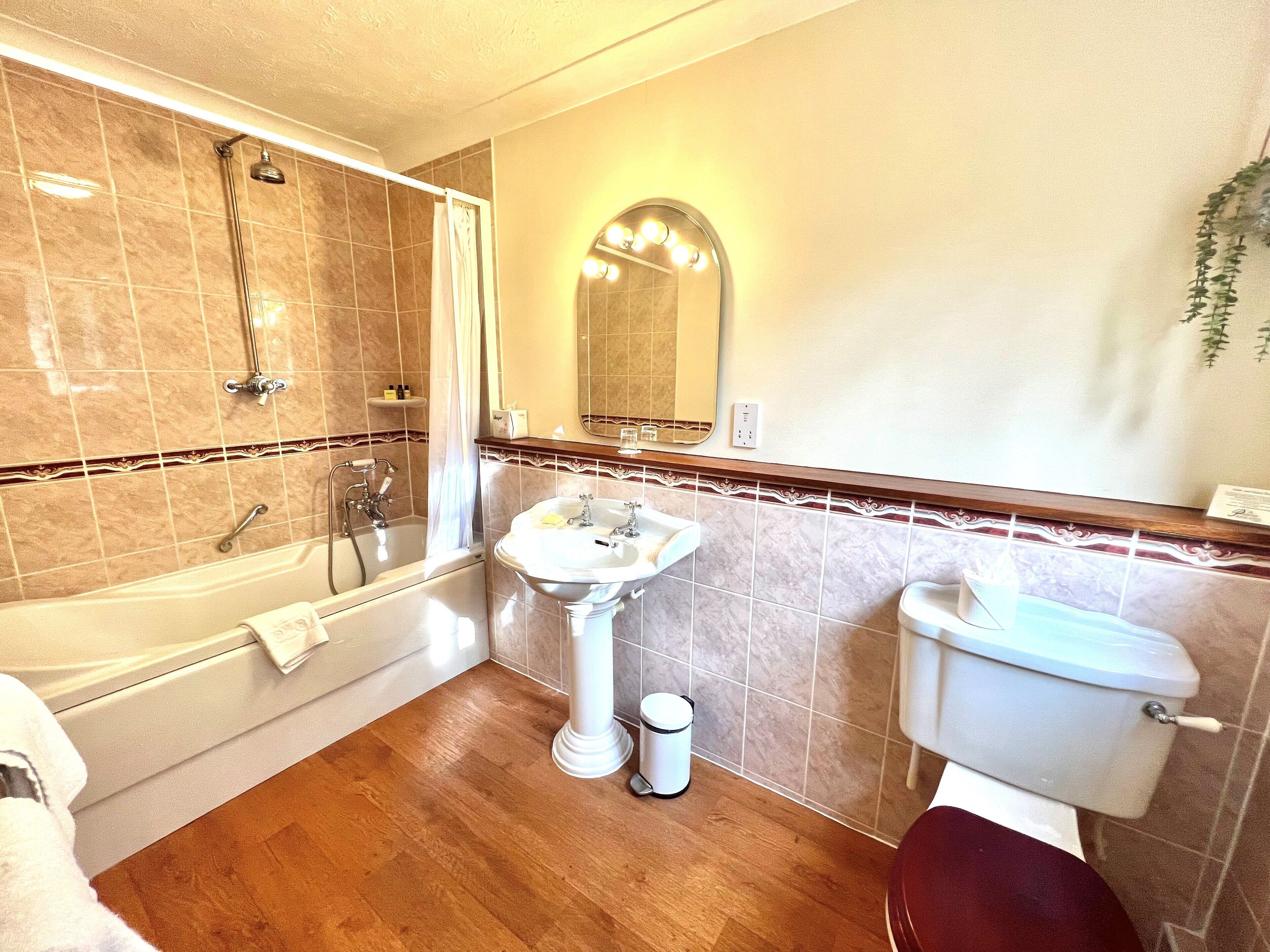 Un baño con bañera, lavabo e inodoro.