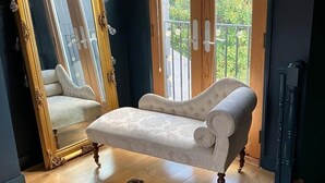 A room with a large mirror, a sofa, a wooden floor, and a view through a door. - the crown loft (Kingston upon Thames)