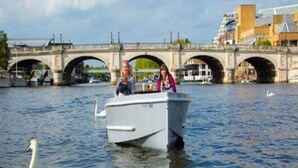 A boat on a river with a bridge in the background. - the crown loft (Kingston upon Thames)