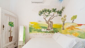Ein Schlafzimmer mit einem Bett, einem Kleiderschrank und einem Wandgemälde.