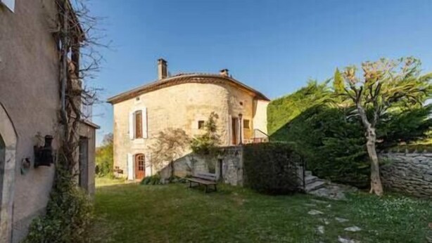A stone house with a sloped roof, a small front porch, and a grassy yard. - Le Clos du Prince, Country house with private pool and enclosed garden, ideal for families! (Saint-Vincent-Rive-d'Olt)